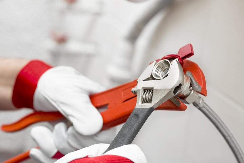 Plumber holding pipe wrenches for an emergency repair in Lutz