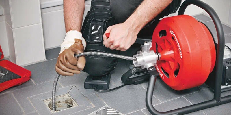 Plumber using a drain-cleaning machine in Lutz