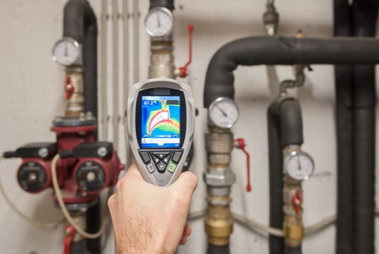 Plumber using a thermal imaging camera to inspect pipes in Lutz