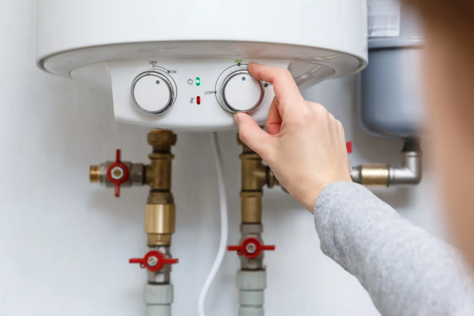 Homeowner adjusting the temperature controls on a water heater in Lutz